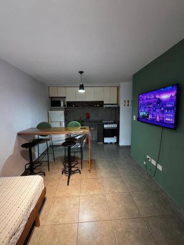 a room with a table and chairs and a kitchen at Dpto en la costa in Villa María