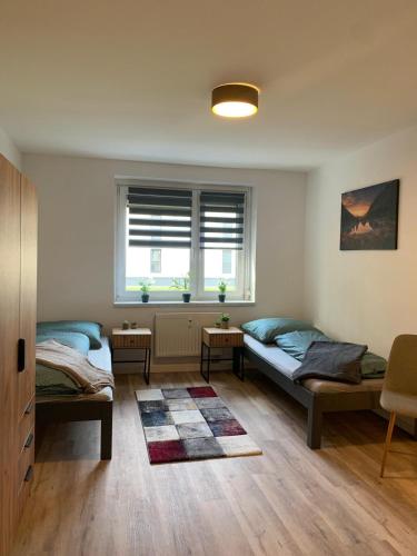 a living room with two beds and a window at moderne Ferienwohnung Nähe Goitzschesee in Greppin