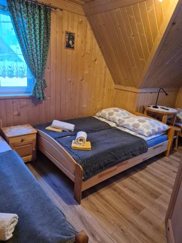 a bedroom with a bed with a hat on it at Miodowa Chatka in Brzegi