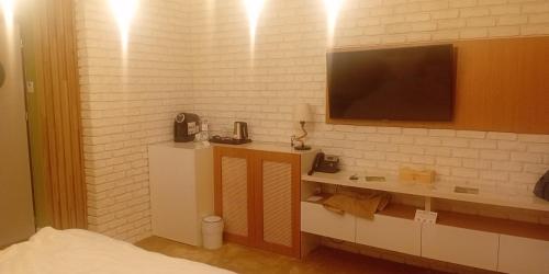 una camera da letto con una TV su una parete di mattoni bianchi di apartament a Chişinău