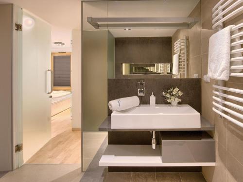 ザコパネにあるVisitZakopane - Aquapark Residence Lux Apartmentのバスルーム(白い洗面台、鏡付)