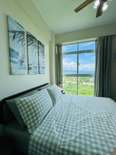 a bedroom with a bed and a large window at Threeos Cabana in Boracay