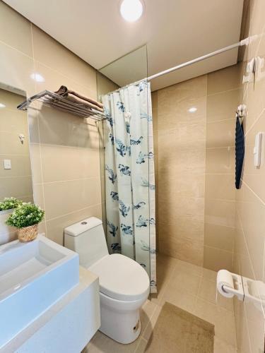 a bathroom with a toilet and a sink and a shower at Threeos Cabana in Boracay