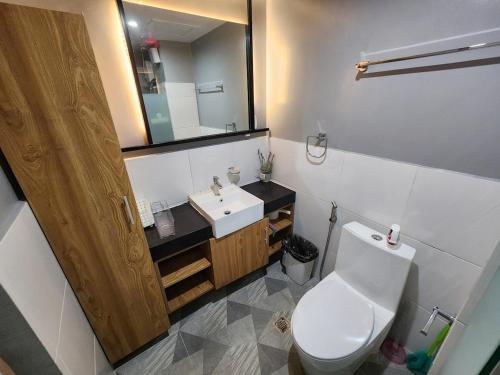 a bathroom with a toilet and a sink and a mirror at 2 Bedroom Corner in Davao City