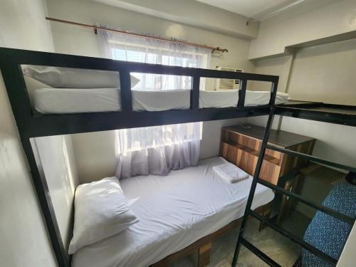 a bedroom with two bunk beds and a window at 2 Bedroom Corner in Davao City