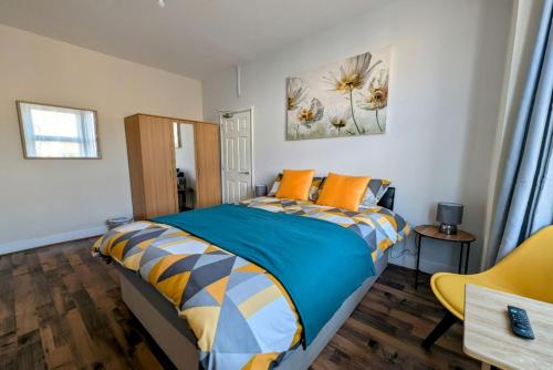 a bedroom with a bed with orange pillows at Spacious Studio with Private Kitchen and Bathroom in Hounslow
