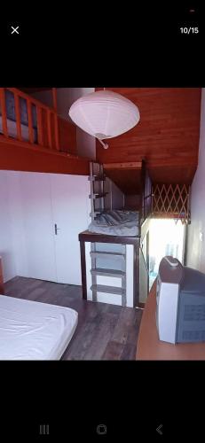a room with a bunk bed and a desk with a microwave at Maison 2-4 personnes, vue sur le Sancy in Murat-le-Quaire
