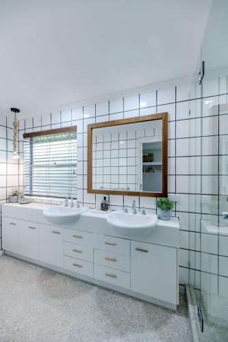 a bathroom with two sinks and a mirror at Luxe Beach House at Sunshine in Sunshine Beach