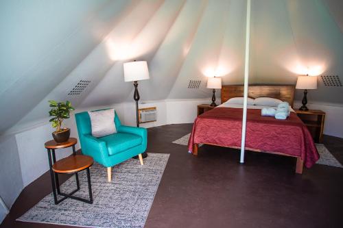 a bedroom with a bed and a blue chair at Hameki in Homún