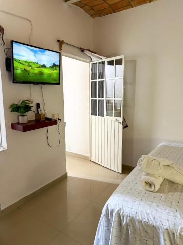 a bedroom with a bed and a flat screen tv on the wall at Casa Baluana vive Sayulita a un paso de todo in Sayulita