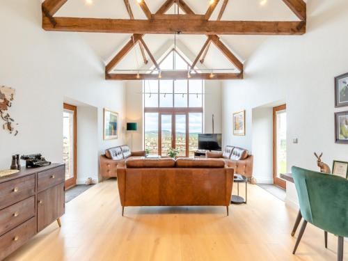 a living room with a couch and a table at Haybale Barn in Chatton