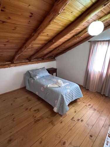 a bedroom with a bed and a wooden ceiling at Las Palomas in Trevelín