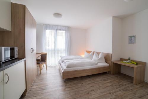 um quarto de hotel com uma cama e um micro-ondas em BoardingHouse N22 Oberboihingen em Oberboihingen