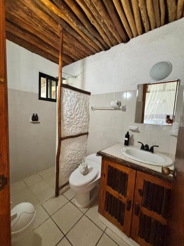 a bathroom with a toilet and a sink at Mayan Mittoz in Holbox Island