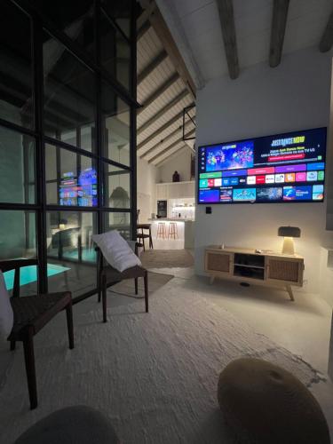 a living room with a large flat screen tv on the wall at Casa do Capitão in Monte Trigo