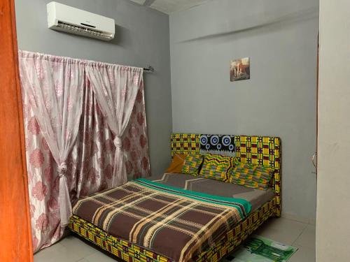 a bedroom with a bed in a room at VOYALUX BENIN Appartement in Cotonou