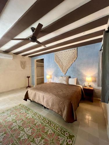 a bedroom with a large bed and a ceiling fan at Casa Lucia Valladolid in Valladolid