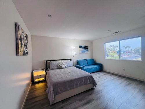 a bedroom with a bed and a blue chair at Stylish & Fully Renovated Home! in Oxnard