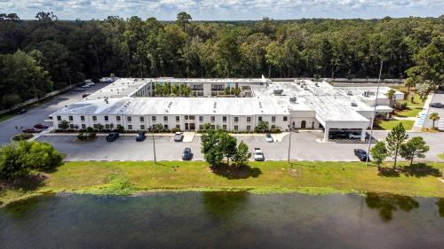 an aerial view of a large white building with a parking lot at Clarks Inn Savannah Airport in Pooler