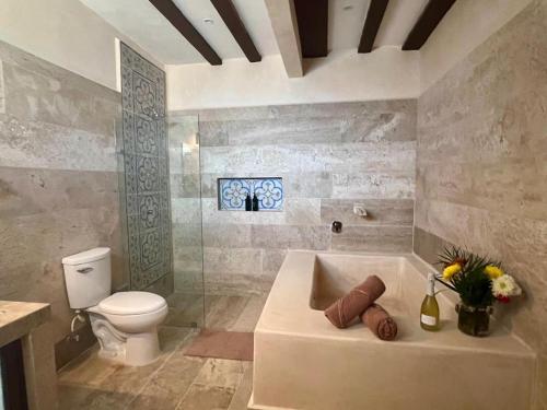 a bathroom with a bath tub and a toilet at Casa Lucia Valladolid in Valladolid