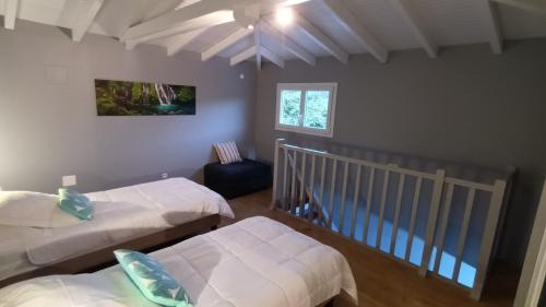 a bedroom with two beds and a crib at LE DOMAINE de L'HYLODE in Sainte-Anne