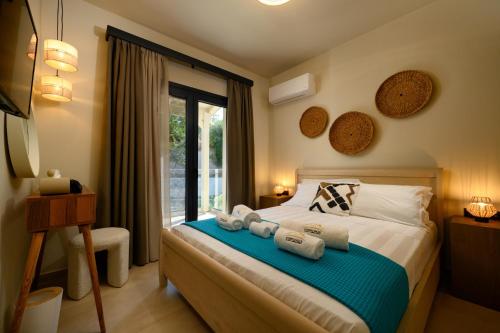 a bedroom with a bed with towels on it at CorfuVille Luxury Villas in Danilia