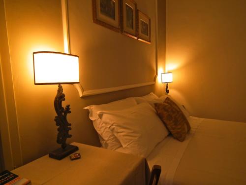 a bedroom with a bed with a lamp and pillows at Suite Umberto I in Assisi