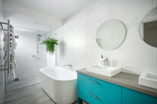 a bathroom with a tub and a sink and a mirror at 13 Mountbatten in Bright