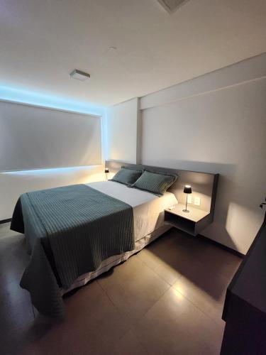 a bedroom with a large bed with a blue light at Apartamento Edifíco Prestige in Marechal Deodoro