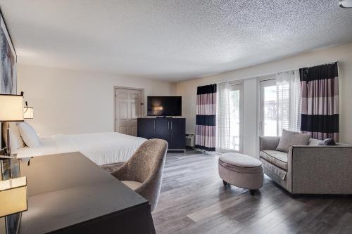 a hotel room with a bed and a living room at Clarks Inn Savannah Airport in Pooler