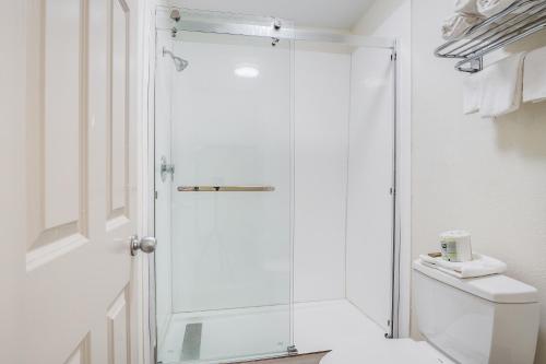 a shower with a glass door in a bathroom at Clarks Inn Savannah Airport in Pooler