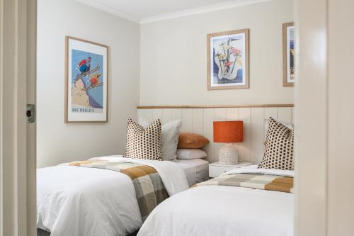 two beds in a room with white walls at 13 Mountbatten in Bright