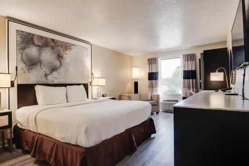 a hotel room with a large bed and a large window at Clarks Inn Savannah Airport in Pooler