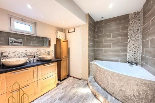 un bagno con due lavandini e una grande vasca di L'instant Douceur a Riorges