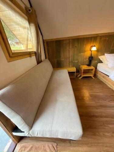 a small room with a bed and a window at A-Frame House บ้านเอเฟรม แดลอร์ปู in Ban Yang