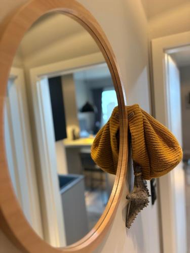 a mirror with a towel hanging on a wall at DESIGNBUTZE by BUTZENFLOTTE Grömitz - Beach Loft & Meerblick in Grömitz
