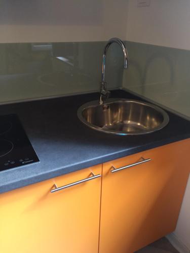 a kitchen counter with a sink and a laptop on it at Cosy Studio Historical Center in Cremona