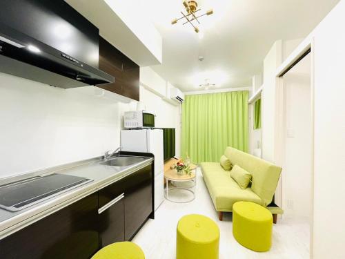 a kitchen with a couch and some yellow stools at The Grand Win in Fukuoka