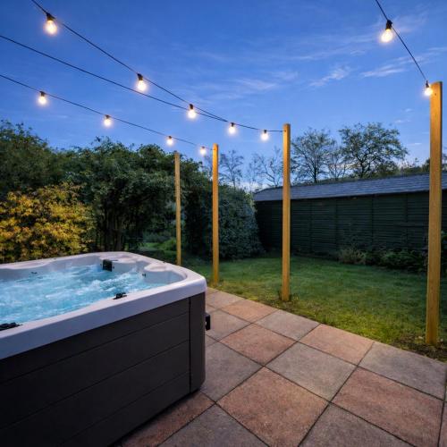 a jacuzzi tub in a yard with lights at Ness on the Lane in Inverness