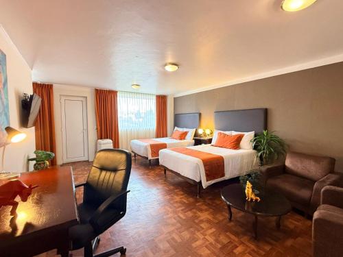 a hotel room with a bed and a couch at Hotel Suites Teziutlan in Teziutlán