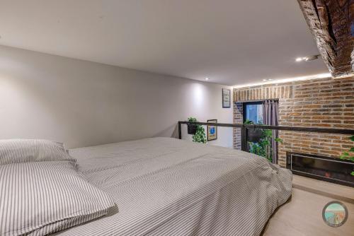 a bedroom with a bed and a brick wall at Chic Industrial Loft Quiet Garibaldi AC Balcony in Nice
