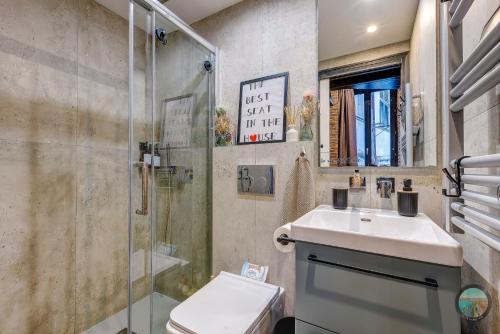 a bathroom with a toilet and a sink and a shower at Chic Industrial Loft Quiet Garibaldi AC Balcony in Nice