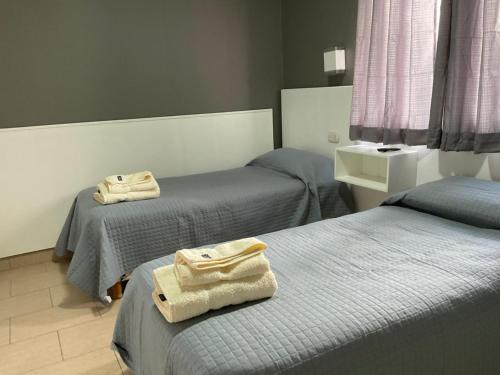 a room with two beds with towels on them at HOTEL EL VIEJO Bar in Perito Moreno