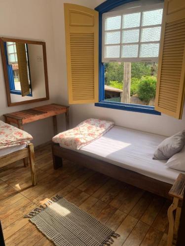a small room with a bed and a window at Casa vila carolla in Tiradentes