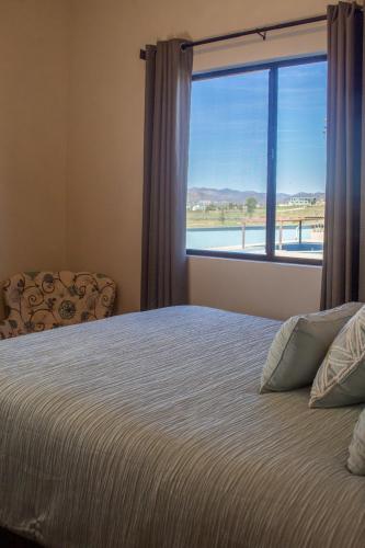 a bedroom with a bed and a large window at Villas Persas by Jardin de Persia in Valle de Guadalupe