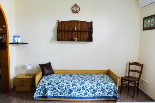 um quarto com uma cama e um relógio na parede em Casa Sanfaso' em Avola