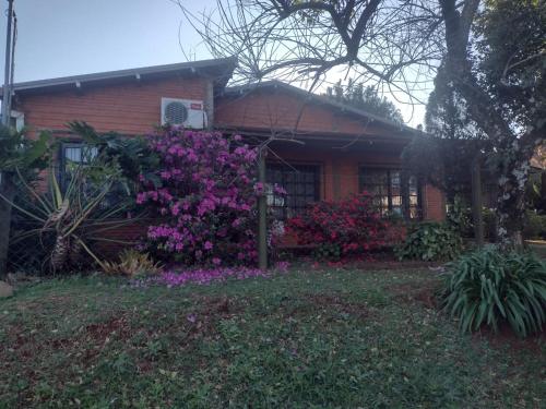 a house with pink flowers in front of it at Casa Paganelli Germano in Aristóbulo del Valle