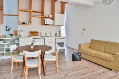 a kitchen and dining room with a table and a couch at A Casa del Rei in Ribeira Grande