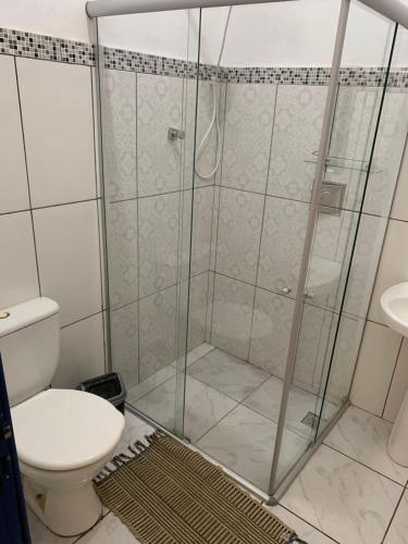 a bathroom with a shower with a toilet and a sink at Casa vila carolla in Tiradentes