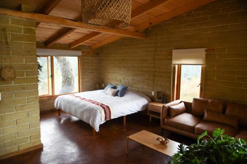 ein Schlafzimmer mit einem Bett und einer Couch in einem Zimmer in der Unterkunft Hangar 5 in San Lucas del Pulque